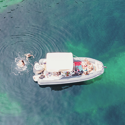 Innovative Unbundled Wealth Management Aerial view of a family with children relaxing on a boat in the blue turquoise sea. Top view. Amazing nature background. The color of the water and beautifully bright. Fresh freedom. Adventure day.