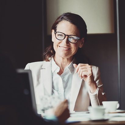 NYC Women & Wealth Happy businesswoman looking at colleague during meeting in hotel room